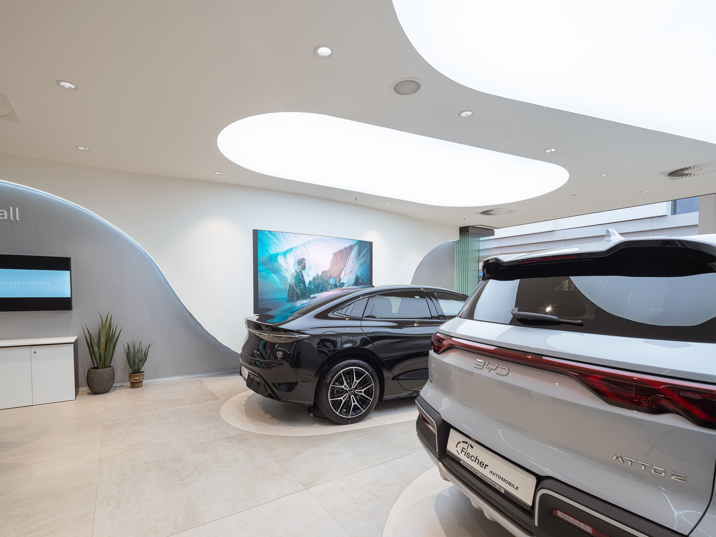 Panoramic view of a BYD car showroom with sculptural ceiling and an electric car – automotive retail design by Vizona
