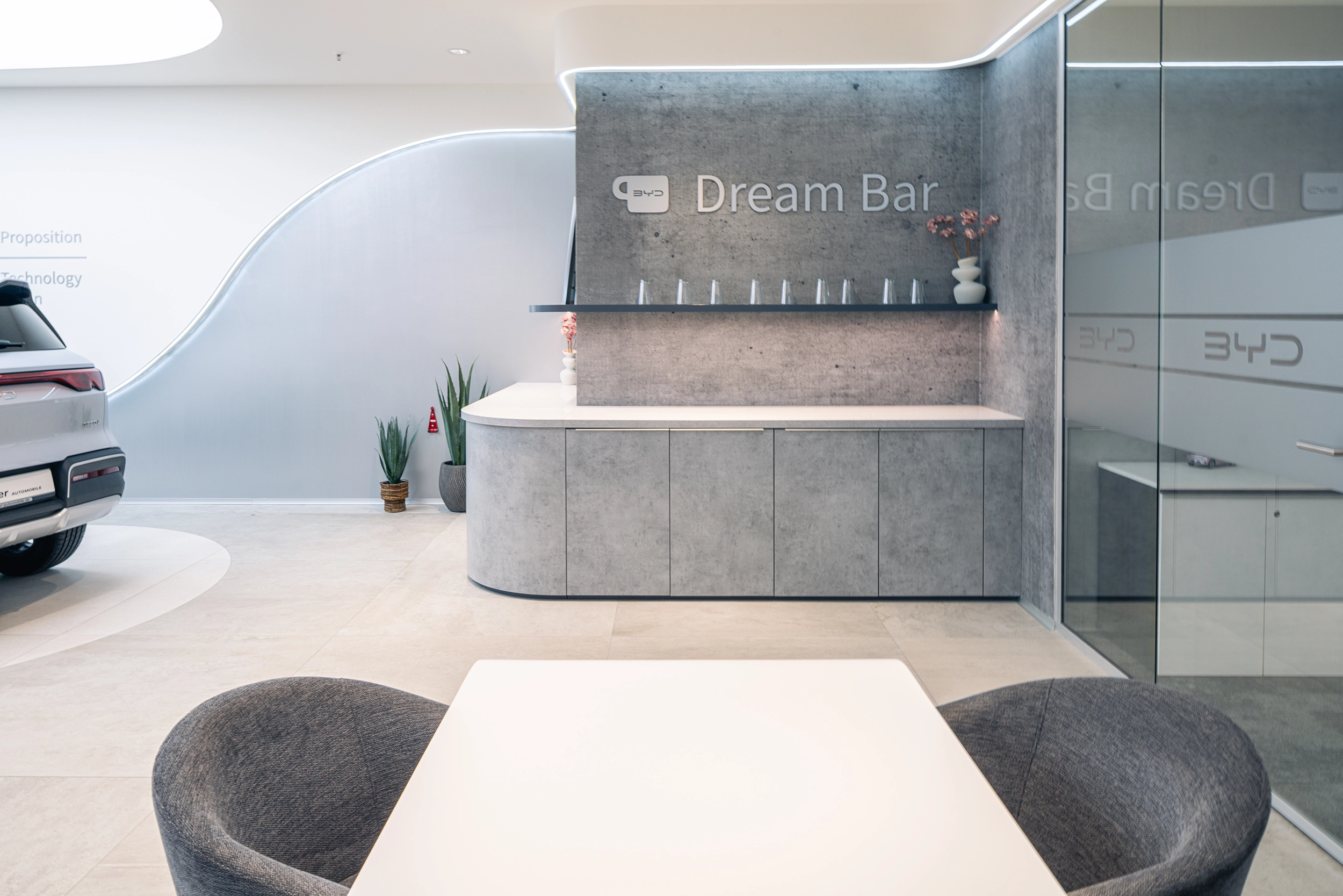 BYD showroom seating lounge with 'Build Your Dreams' branding – car dealership interior design by Vizona